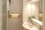 Discover a modern and minimalist bathroom featuring a sleek sink and vanity area with a large mirror.