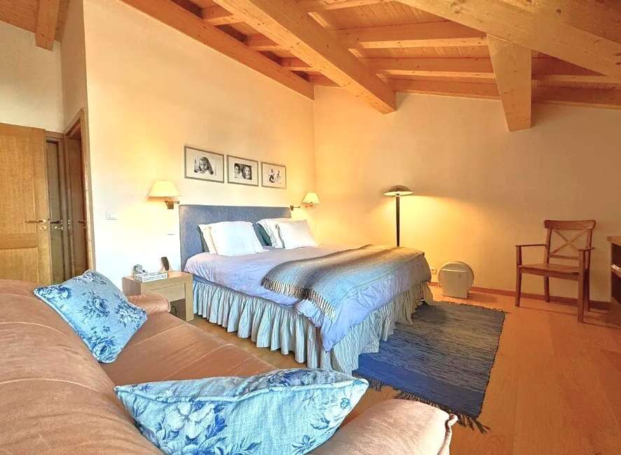 This charming bedroom features a cozy ambiance with its wooden ceiling and warm lighting.
