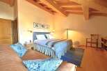 This charming bedroom features a cozy ambiance with its wooden ceiling and warm lighting.
