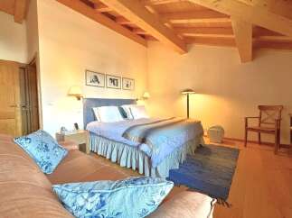 This charming bedroom features a cozy ambiance with its wooden ceiling and warm lighting.