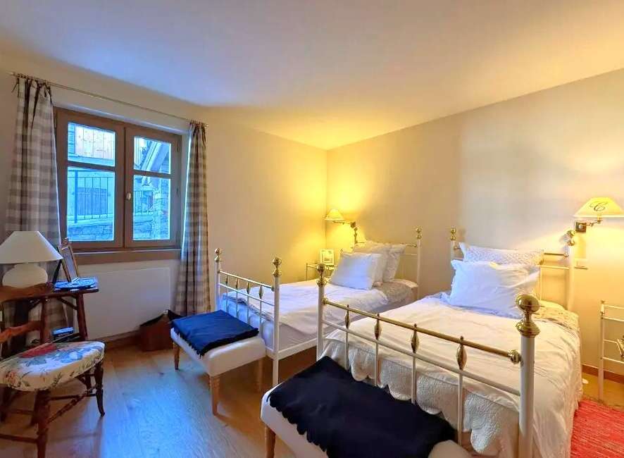 This charming bedroom features two twin beds with elegant white frames, perfect for guests or a cozy shared space.