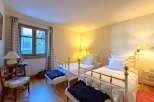 This charming bedroom features two twin beds with elegant white frames, perfect for guests or a cozy shared space.