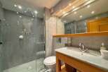 This stunning bathroom features a luxurious walk-in shower with a rain showerhead and elegant marble-like tiles.