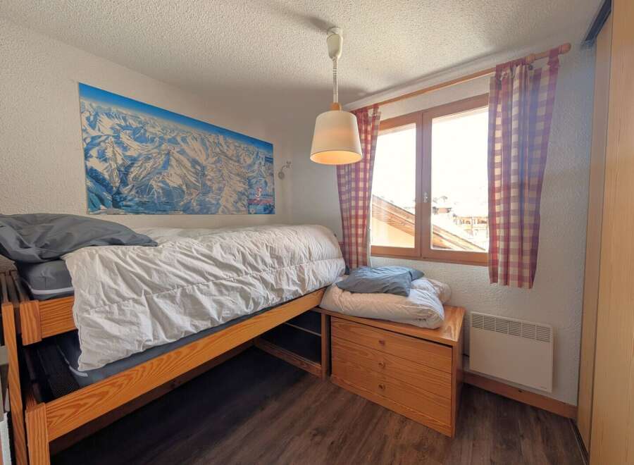 This cozy bedroom features a comfortable bed with a map of the mountains on the wall, perfect for a relaxing stay.