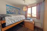 This cozy bedroom features a comfortable bed with a map of the mountains on the wall, perfect for a relaxing stay.