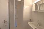 Step into a clean and modern bathroom, featuring a sleek shower enclosure and pristine white tiling.