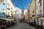 Explore the charm of this historic European town, featuring colorful buildings and a cobblestone street.