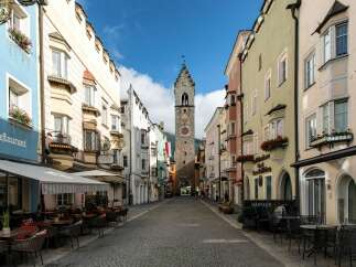 Explore the charm of this historic European town, featuring colorful buildings and a cobblestone street.