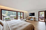 Experience luxury living in this stunning bedroom with breathtaking mountain views.