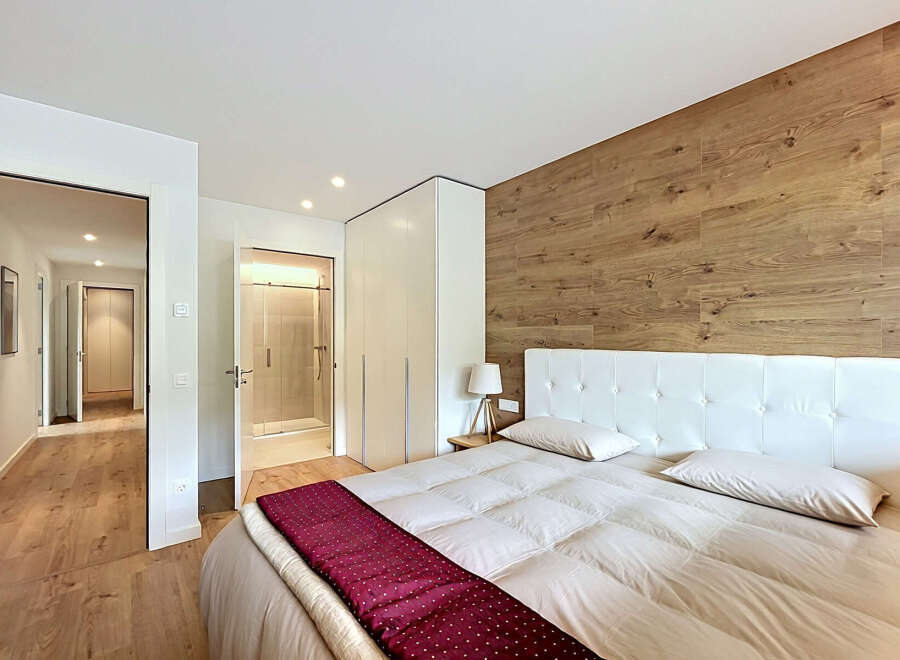 This stunning bedroom boasts a modern design with a touch of warmth, featuring a beautiful wooden accent wall.