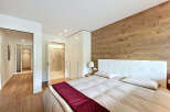 This stunning bedroom boasts a modern design with a touch of warmth, featuring a beautiful wooden accent wall.