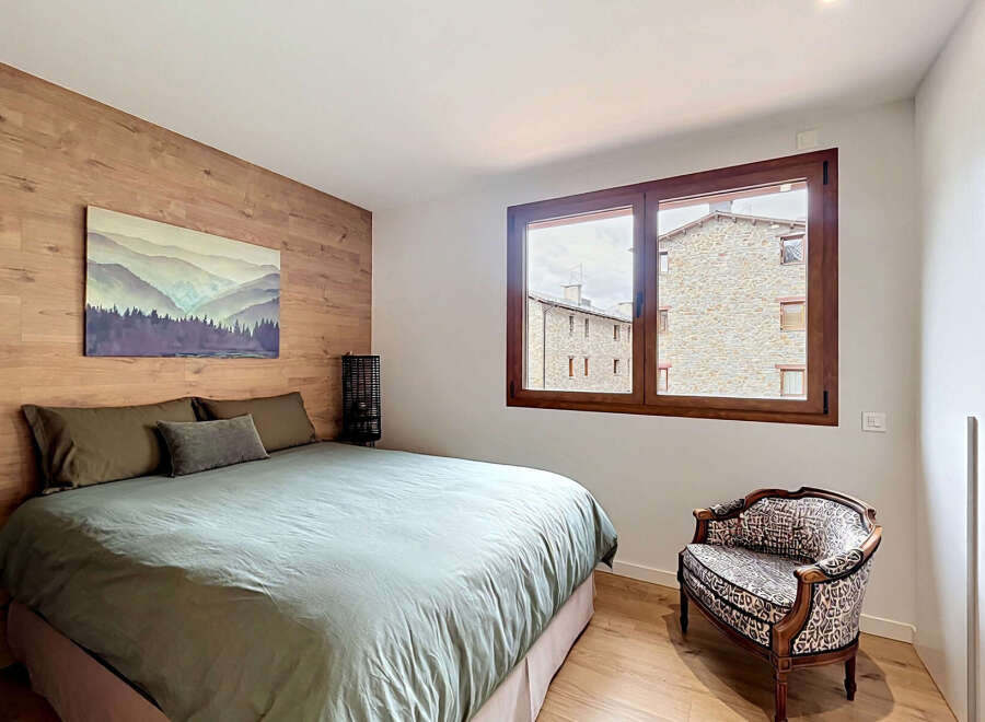 Discover the charm of this inviting bedroom, featuring a stunning wooden accent wall and a cozy bed.