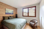 Discover the charm of this inviting bedroom, featuring a stunning wooden accent wall and a cozy bed.