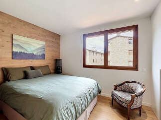 Discover the charm of this inviting bedroom, featuring a stunning wooden accent wall and a cozy bed.