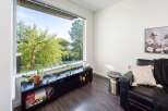 This stunning living space boasts a modern design with a large window offering breathtaking views of lush greenery.