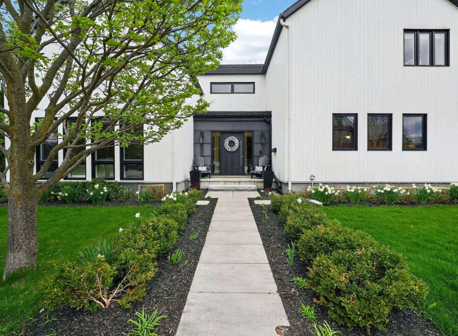 This stunning modern farmhouse boasts a striking exterior with crisp white siding and sleek black accents.