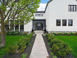 This stunning modern farmhouse boasts a striking exterior with crisp white siding and sleek black accents.