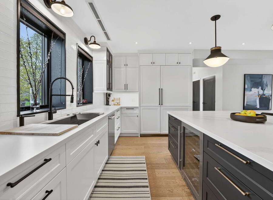 This stunning kitchen boasts a modern design with sleek white cabinetry and a spacious island, perfect for both cooking and entertaining.