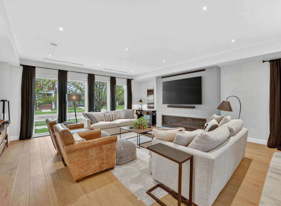 Step into luxury with this stunning living room, featuring a modern fireplace and a large flat-screen TV, perfect for cozy evenings.