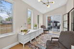 Step into this bright and airy living space, featuring a stylish white dresser and elegant armchairs.
