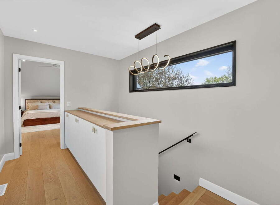 This stunning property boasts a modern design with a sleek staircase and a stylish light fixture.