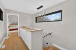 This stunning property boasts a modern design with a sleek staircase and a stylish light fixture.