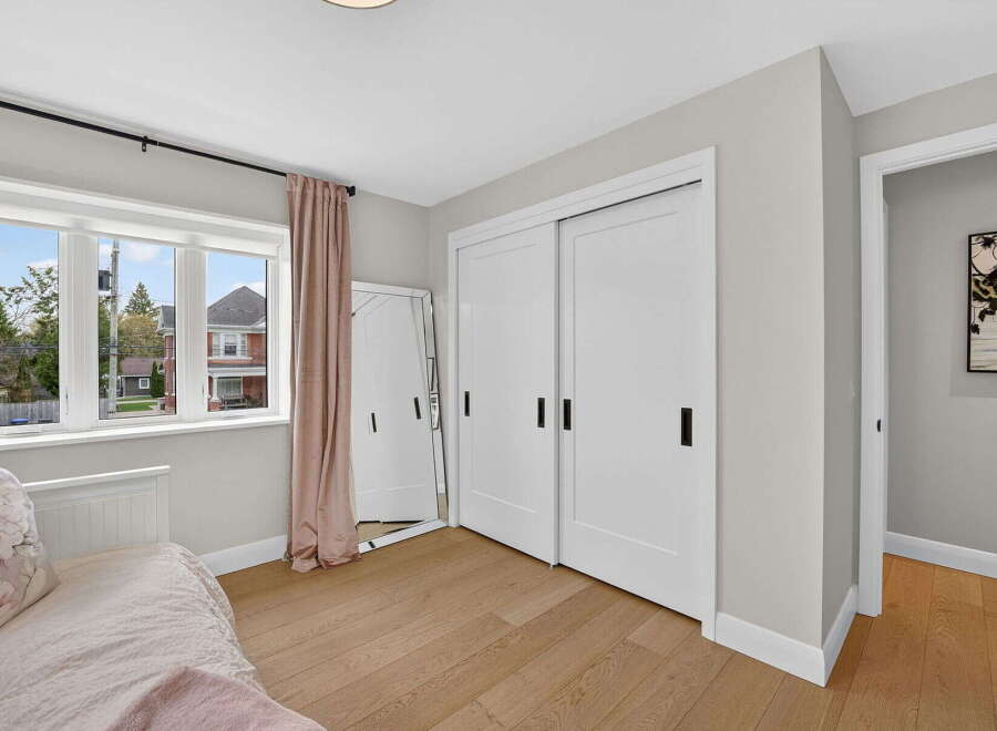 Step into this bright and airy bedroom, featuring a large window that floods the space with natural light.