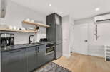 Discover modern living in this stylish kitchen, featuring sleek gray cabinetry and a stainless steel refrigerator.