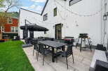 Enjoy outdoor living at its finest with this stunning property! Featuring a modern patio with a dining set, perfect for entertaining.
