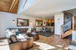 Step into luxury with this stunning property, featuring a spacious living area with a cozy leather sofa and a rustic wooden chest.