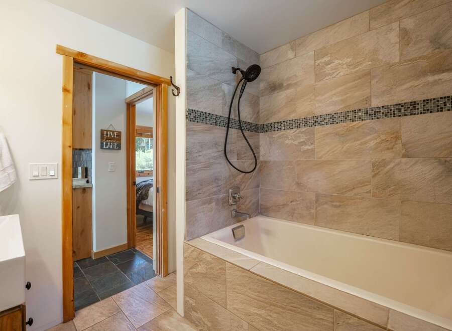Step into this beautifully designed bathroom, featuring a luxurious bathtub and stylish tile work.
