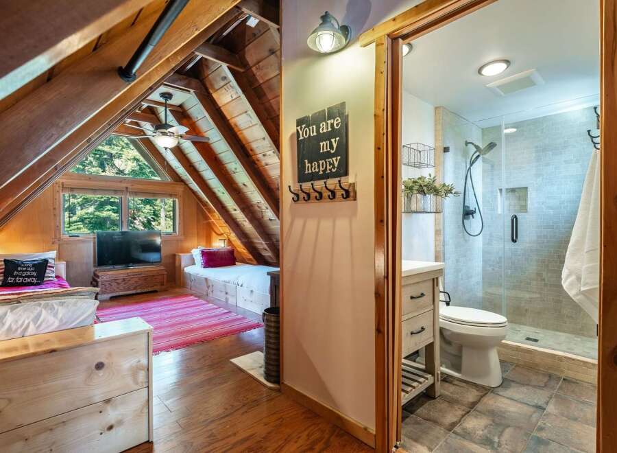 Discover the charm of this cozy cabin retreat! Featuring a unique A-frame design with exposed wooden beams, this property offers a blend of rustic elegance and modern comfort.