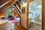 Discover the charm of this cozy cabin retreat! Featuring a unique A-frame design with exposed wooden beams, this property offers a blend of rustic elegance and modern comfort.
