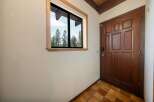 Step into this inviting entryway, featuring a beautiful wooden door and a window that offers a scenic view.