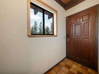 Step into this inviting entryway, featuring a beautiful wooden door and a window that offers a scenic view.