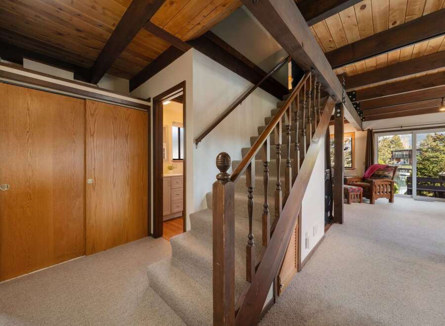 Step into this inviting home featuring a stunning staircase with wooden accents and a cozy carpeted floor.