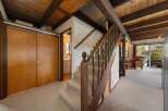 Step into this inviting home featuring a stunning staircase with wooden accents and a cozy carpeted floor.