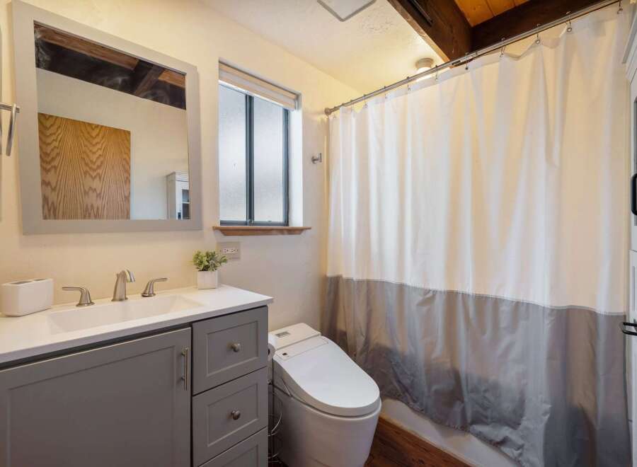 Step into this beautifully designed bathroom, featuring a modern vanity with ample storage and a sleek sink.