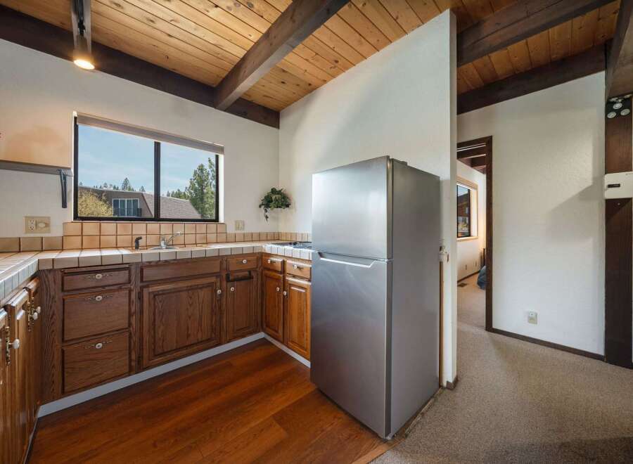 Step into this charming kitchen, featuring warm wooden cabinetry and a stainless steel refrigerator.
