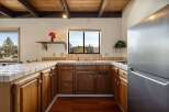 Step into this charming kitchen, featuring warm wooden cabinetry and a tiled countertop.