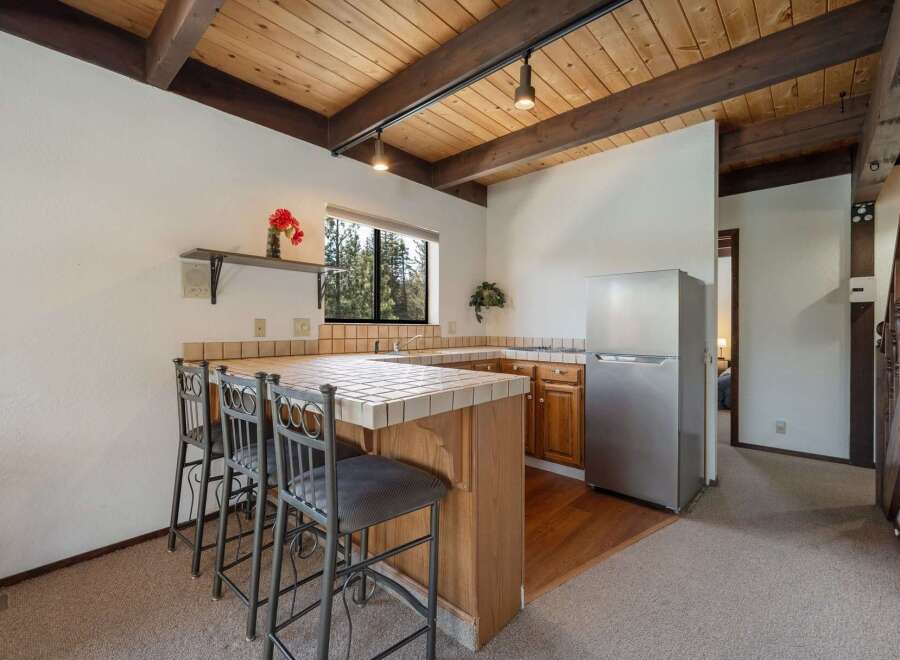 This charming kitchen features a cozy breakfast bar with seating for three, perfect for casual dining or entertaining.