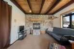 This cozy living space features a stunning stone fireplace, perfect for those chilly evenings.