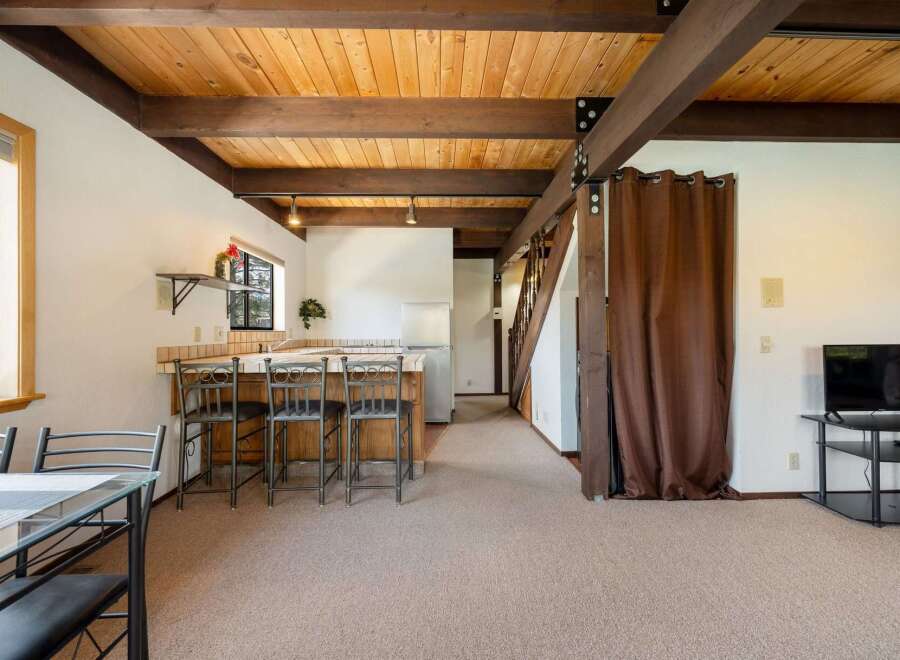 Step into this inviting space featuring a warm, wooden ceiling and exposed beams, creating a cozy atmosphere.