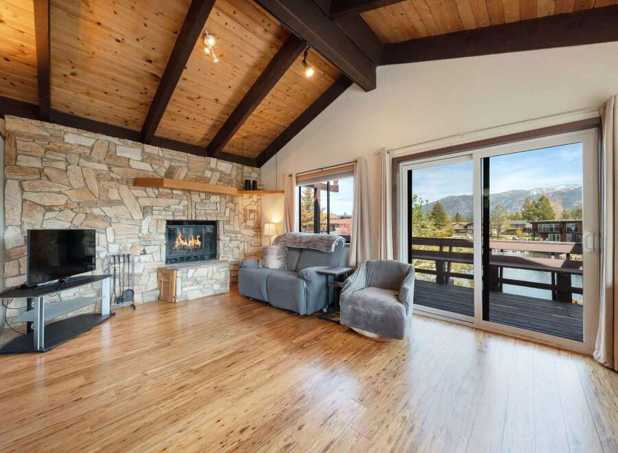 Experience the warmth of this stunning living room, featuring a cozy fireplace and a beautiful stone facade.