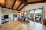 Experience the warmth of this stunning living room, featuring a cozy fireplace and a beautiful stone facade.