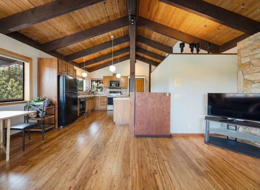Step into this stunning home featuring a warm and inviting interior with beautiful wooden floors and a vaulted ceiling.