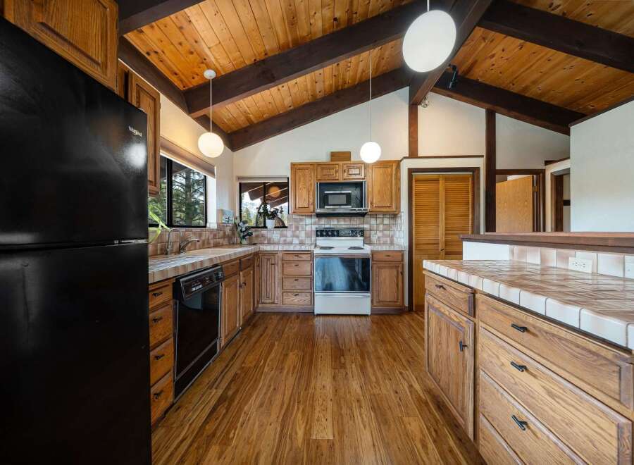 Step into this charming kitchen, featuring a warm, inviting atmosphere with its wooden cabinetry and flooring.