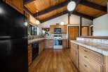 Step into this charming kitchen, featuring a warm, inviting atmosphere with its wooden cabinetry and flooring.