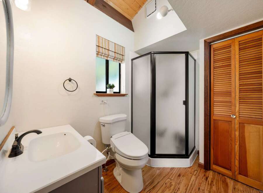 Step into this charming bathroom featuring a modern shower and a stylish vanity.