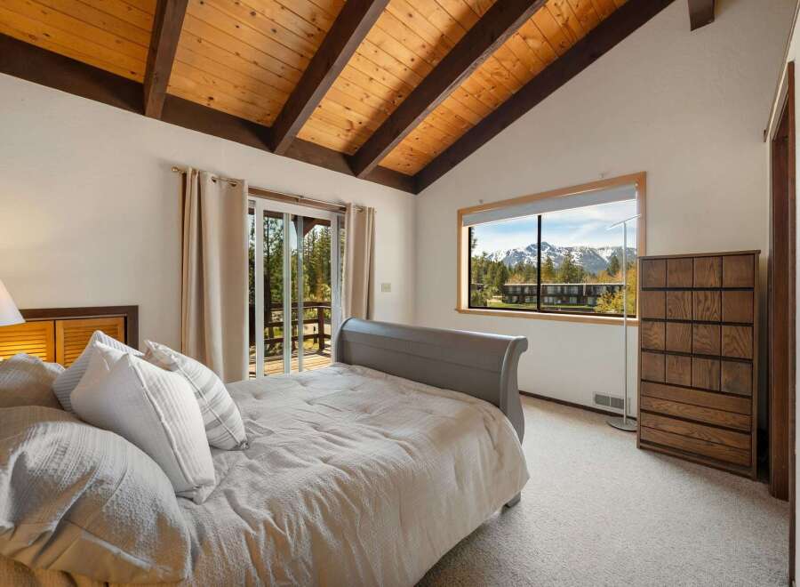 This stunning bedroom boasts a vaulted, wood-paneled ceiling and a cozy, inviting atmosphere.